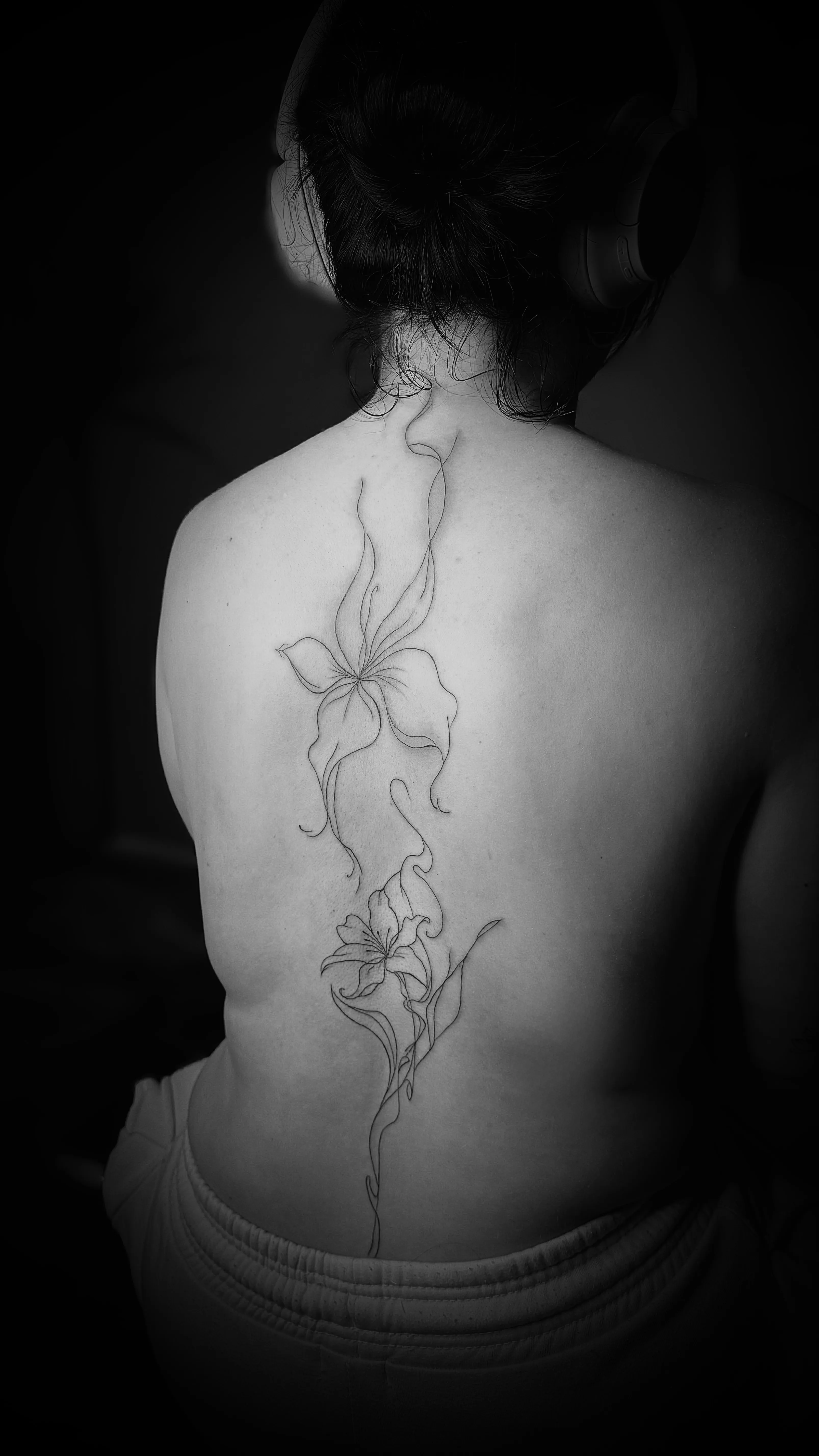 Delicate bloementattoo op de rug